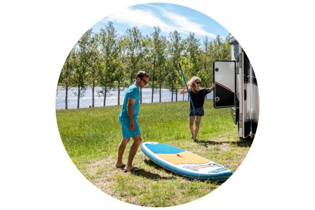 Voyageurs profitant d’une session de surf pendant leurs vacances en camping-car compact Challenger, entre sport, mer et liberté.