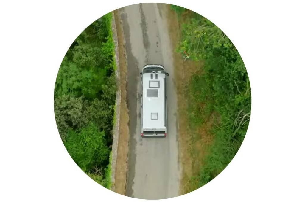 Vue aérienne d’un van compact sur une route sinueuse, illustrant l’esprit d’aventure et de van life sans limites.