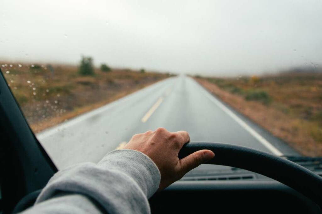 Van compact Challenger roulant sur une route panoramique, incarnation de la liberté et du voyage au grand air.