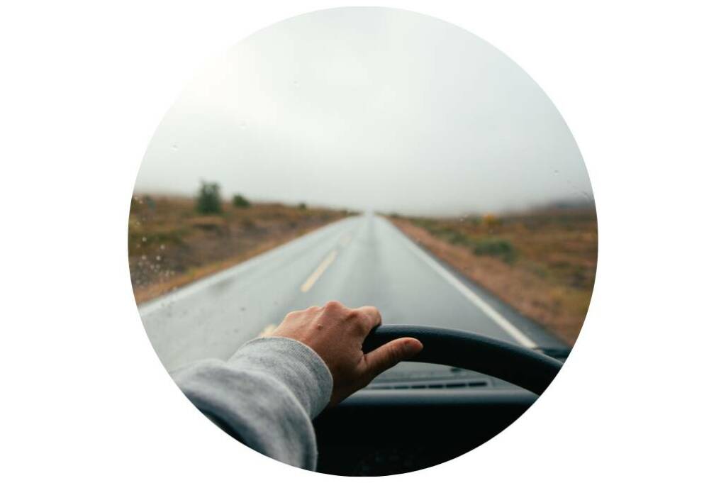 Van compact Challenger roulant sur une route panoramique, incarnation de la liberté et du voyage au grand air.